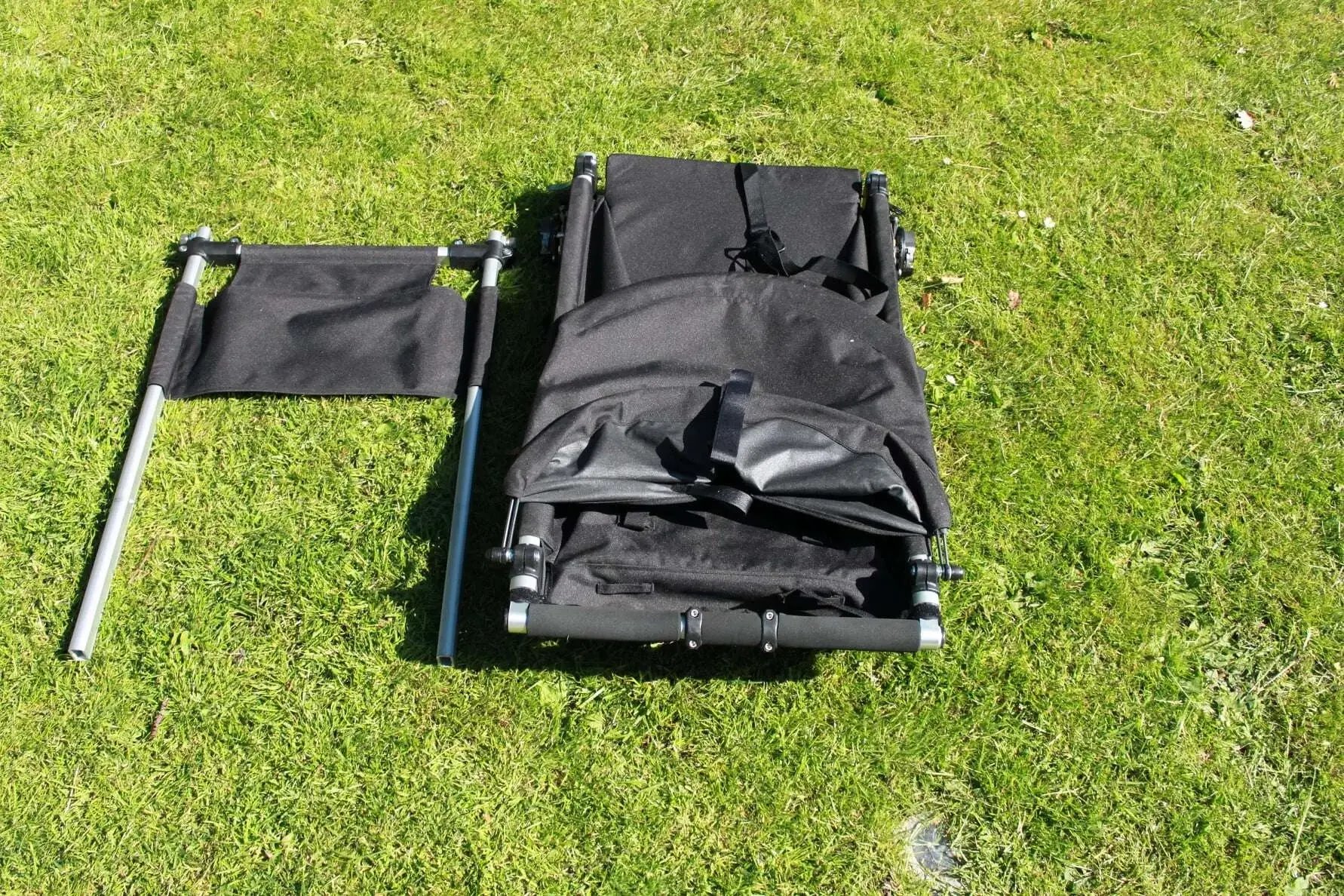 KFN 4Wheeler helt hopfälld på gräsmatta med separat ryggdel bredvid.