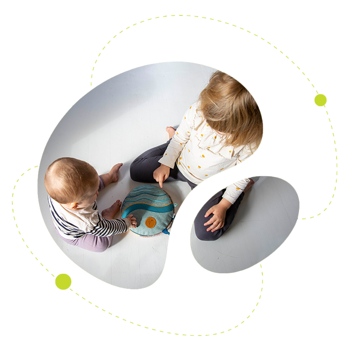 Två barn som leker med en sensorisk kudde på golvet – lek, trygghet och utveckling.